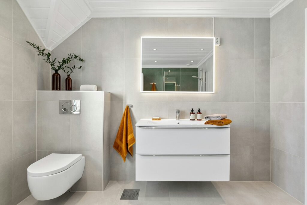 A bathroom with a toilet, sink and mirror